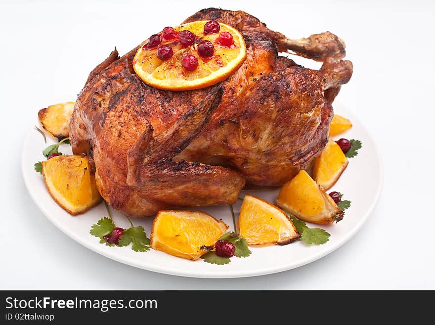 Roasted festive chicken garnished with fruit on a white background. Roasted festive chicken garnished with fruit on a white background