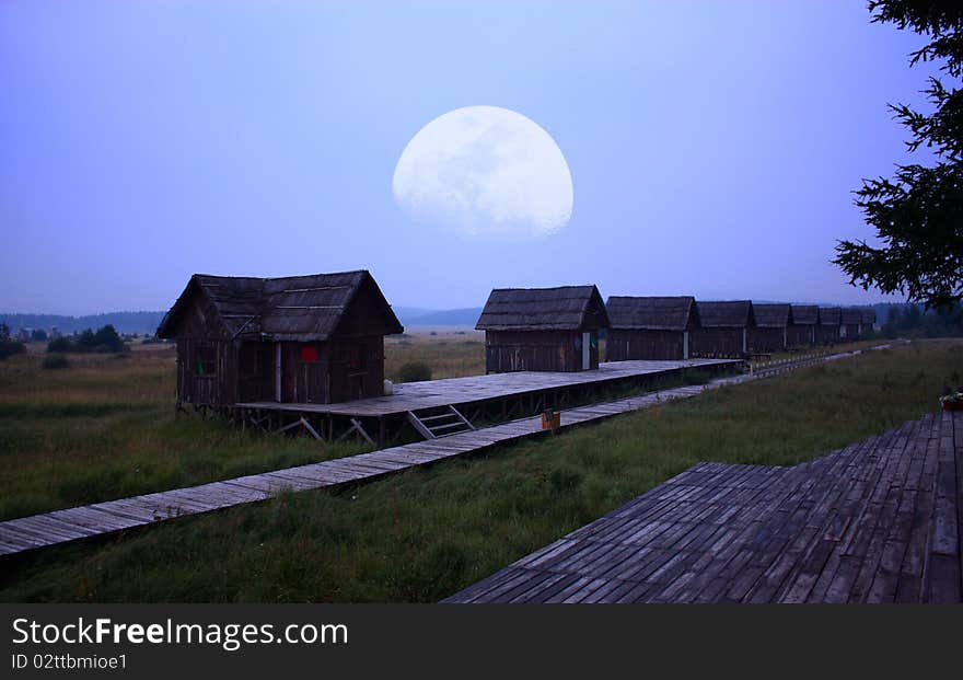 Log cabin with the moon at night.