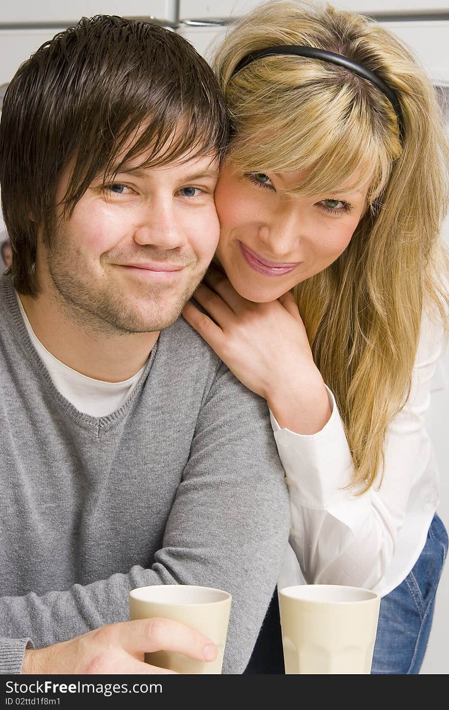 Happy young couple with coffee drink at home