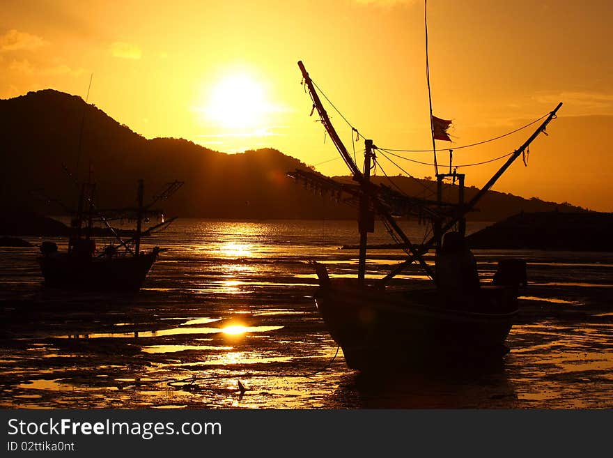 Sunshine and fishing boat on the betch