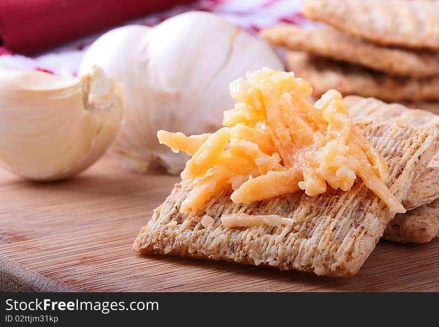 Wheat crackers on a kitchen board with grated cheese. Wheat crackers on a kitchen board with grated cheese.