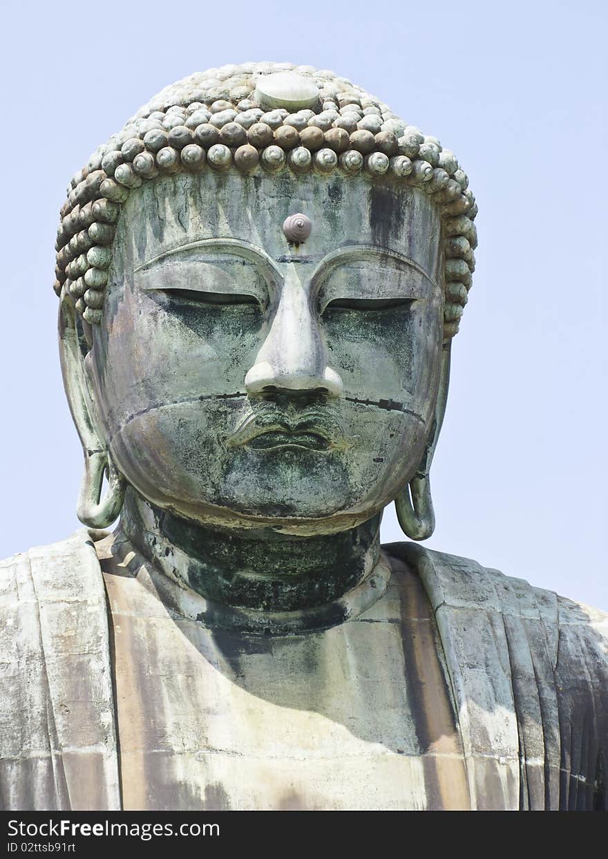 A close-up view of a very big statue of Amida Buddha in Kamakura, Japan, with afternoon light. A close-up view of a very big statue of Amida Buddha in Kamakura, Japan, with afternoon light.