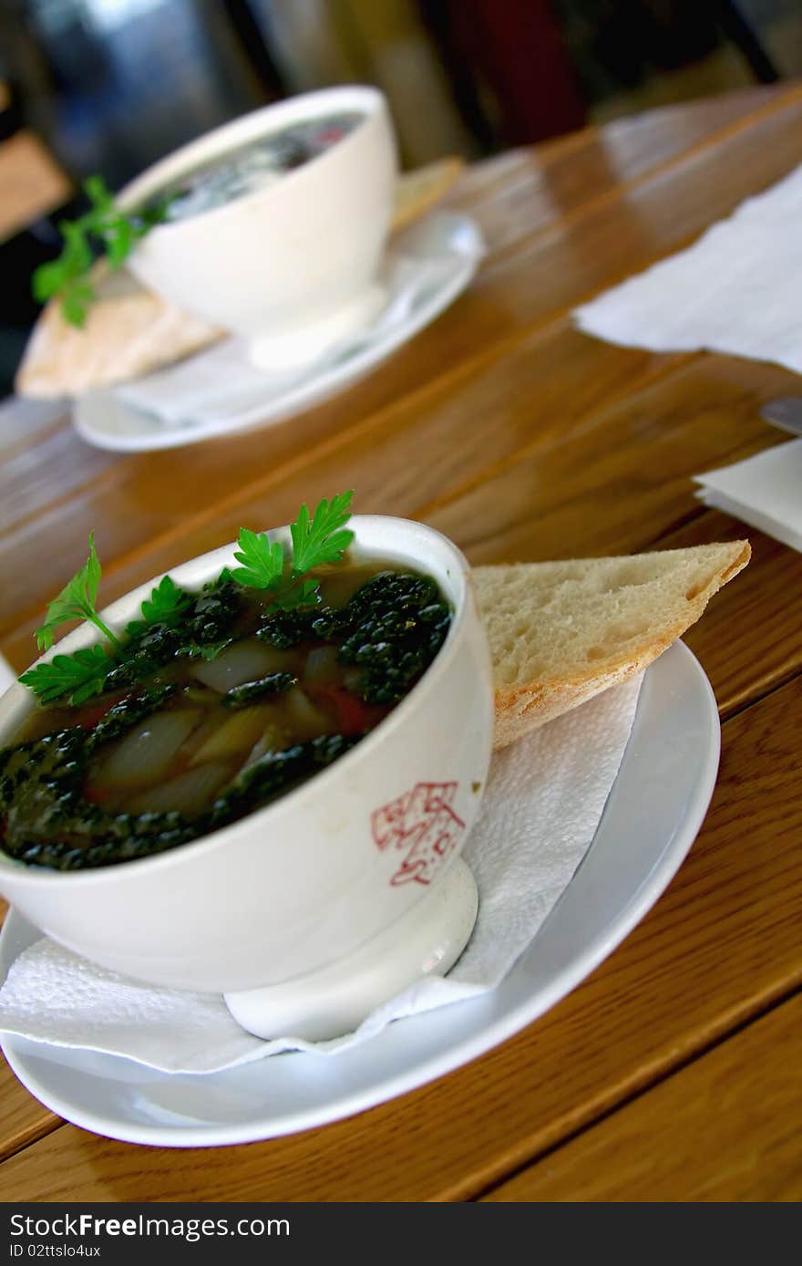 Two bowls with Vegetable soup on wooden table.