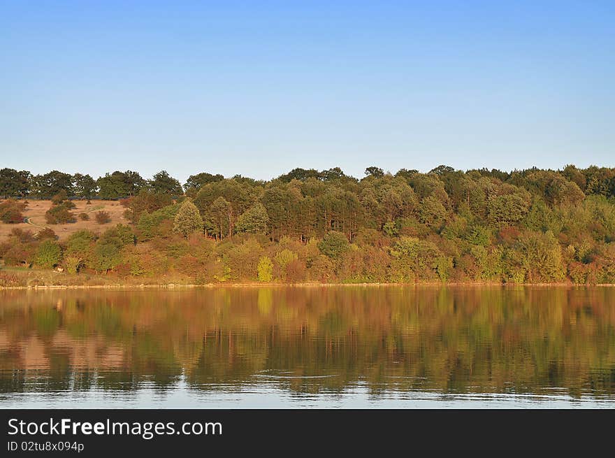 Reflection of colorful trees in water during autumn time. Reflection of colorful trees in water during autumn time