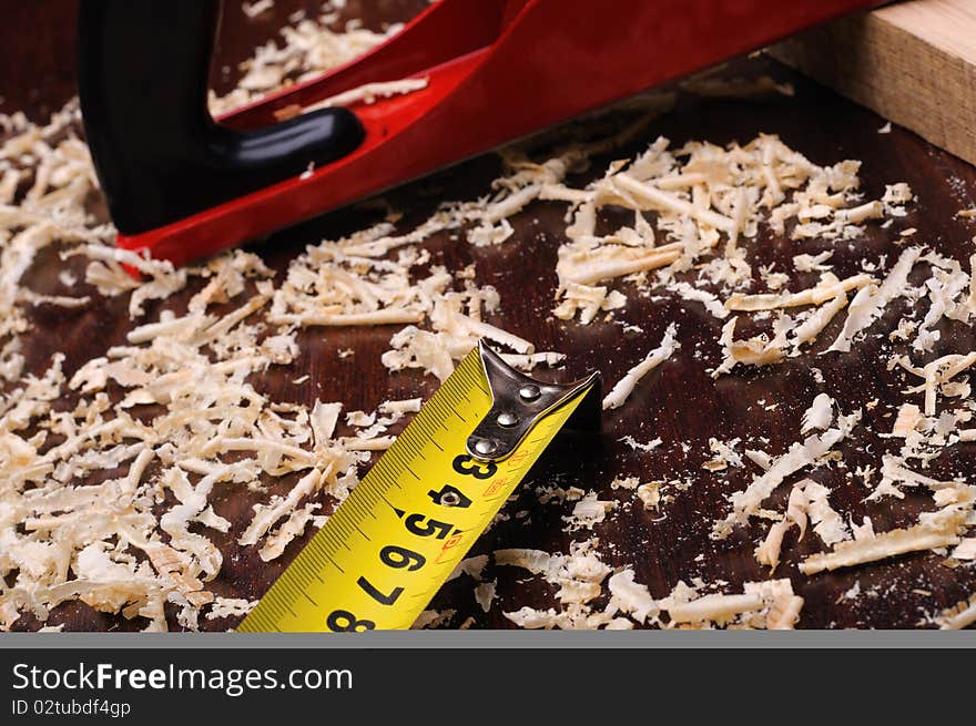 Wood shavings and various construction tools on dark background