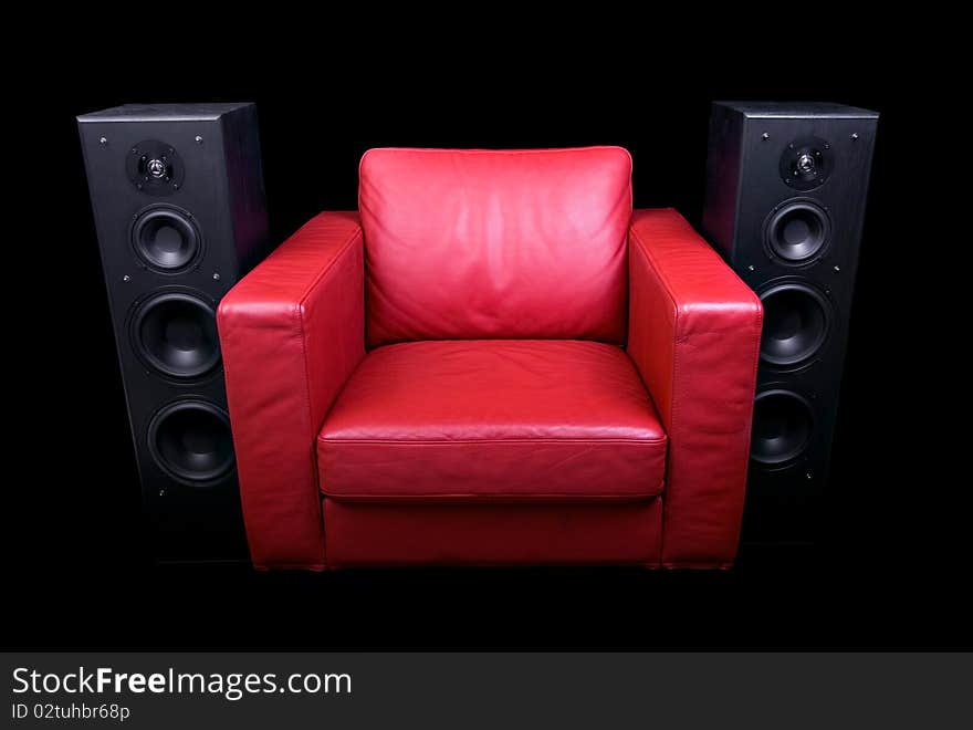 Red leather chair, flanked by speakers and isolated on black. Red leather chair, flanked by speakers and isolated on black.