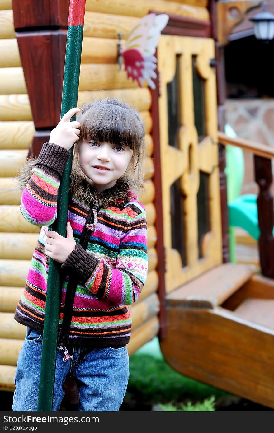 Adorable preschooler girl in colorful sweater on playground. Adorable preschooler girl in colorful sweater on playground