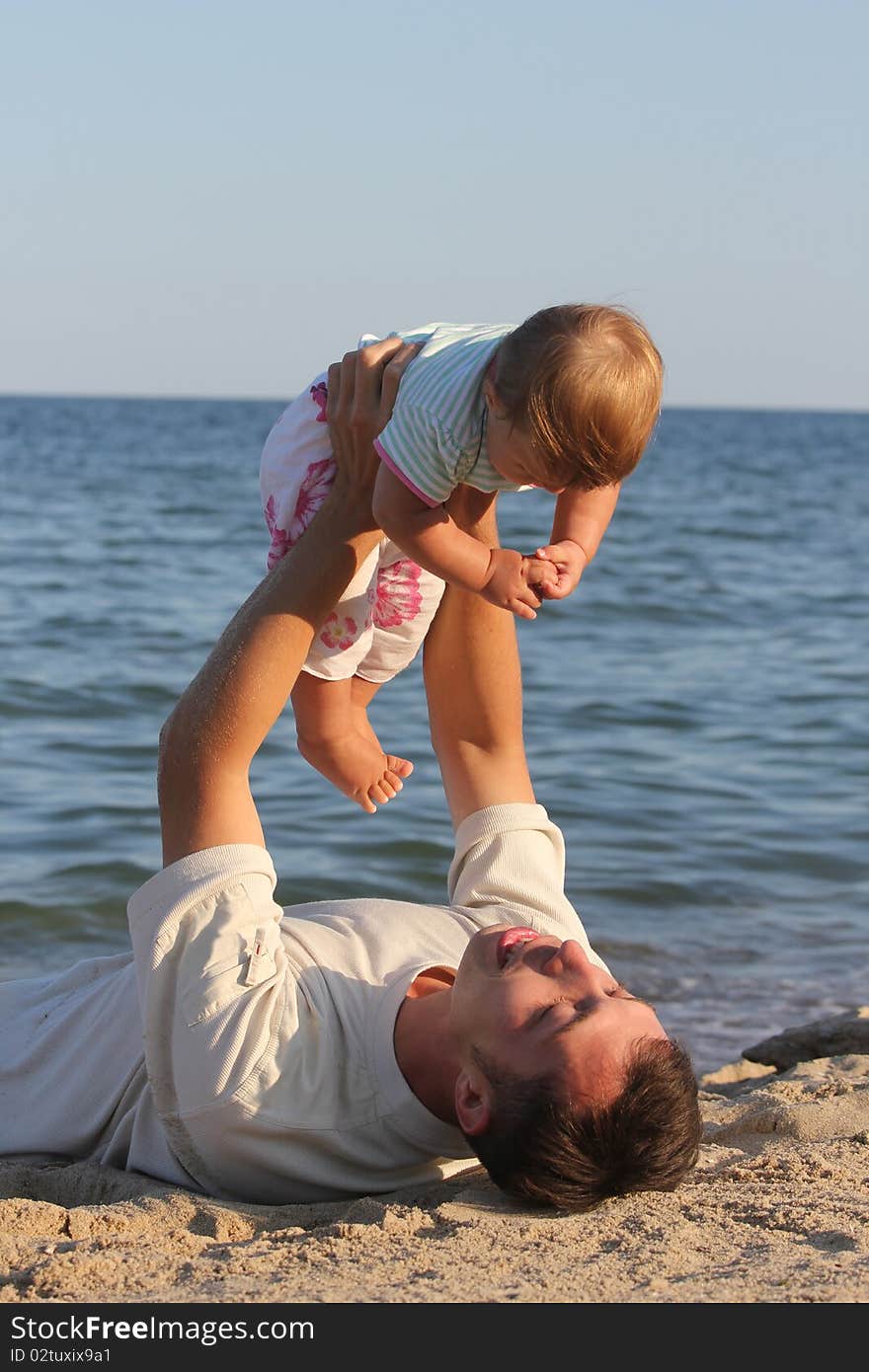 Father and daughter playing near the sea