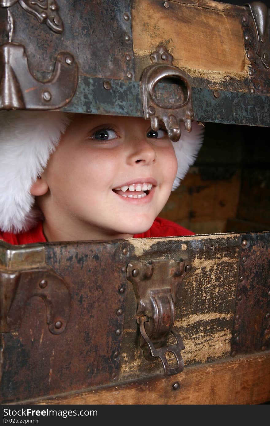 Beautiful blue eyed boy peeping from within an antique trunk. Beautiful blue eyed boy peeping from within an antique trunk