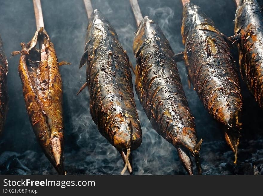 Mackerel with wooden spit on a barbecue