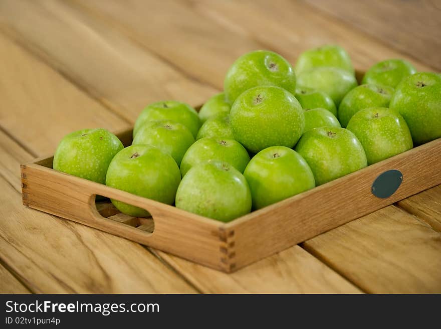 Freshly harvested apples on a wooden tray