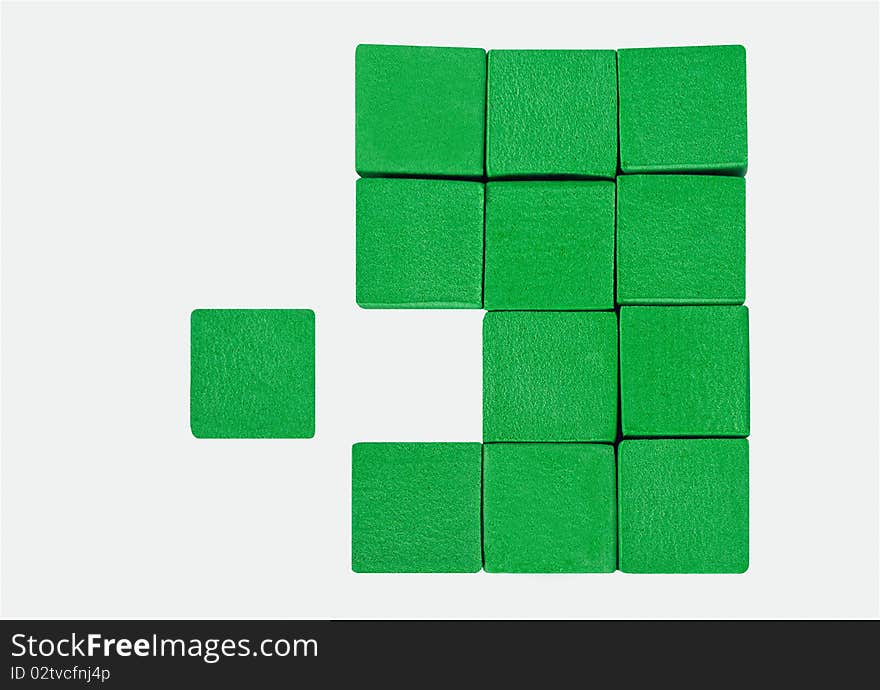 A cluster of green cubes with one cube missing. Another green cube sits off to the side, a perfect fit for the empty space.