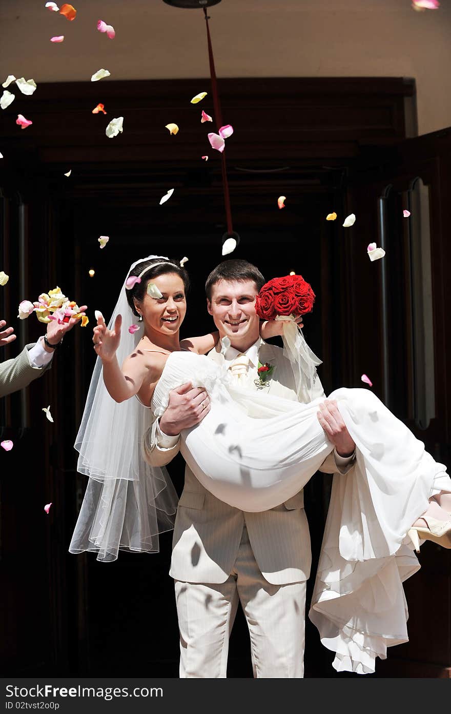 Newly wed couple being showered in rose petals