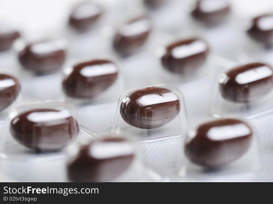 Package of brown pills close up