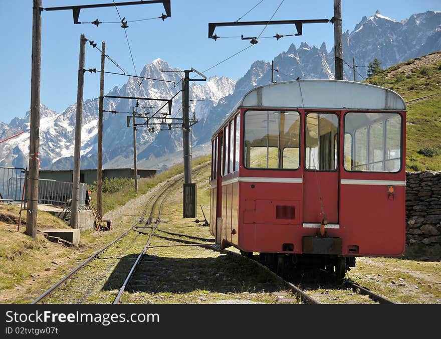 View of rail and coach with mountains in background. View of rail and coach with mountains in background.