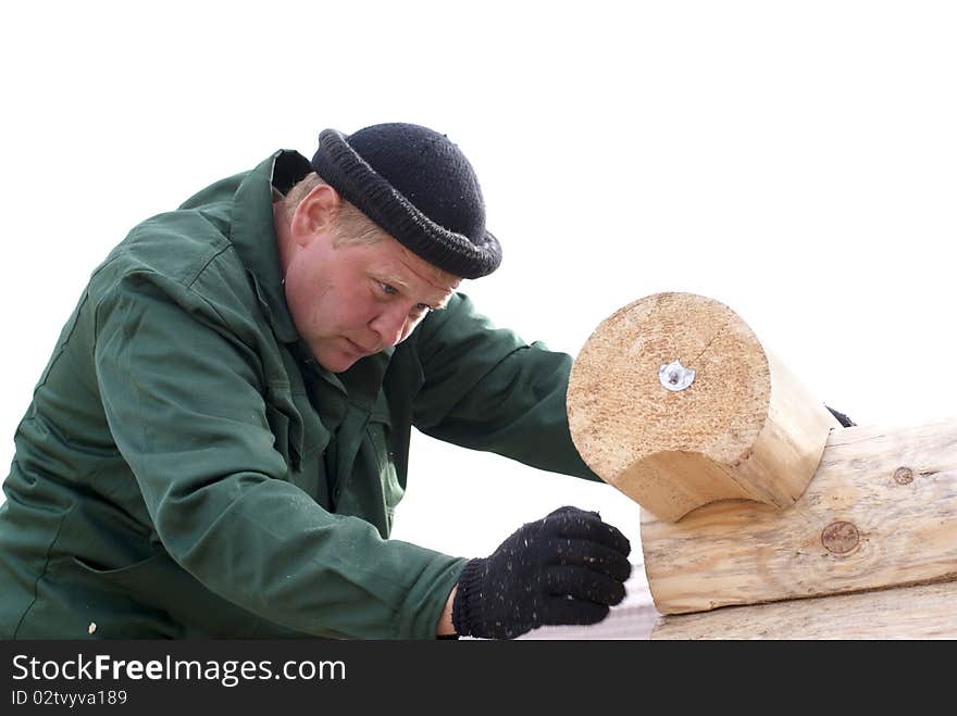 Carpenters works on the wall of log cabin isolated on white. Carpenters works on the wall of log cabin isolated on white