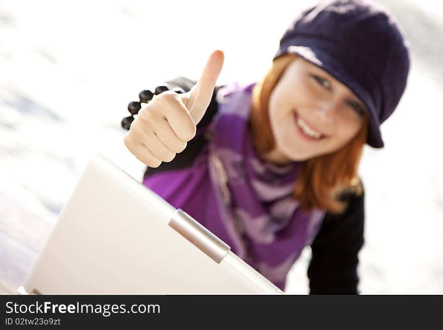 Portrait of red-haired girl with laptop at beach show OK symbol. Portrait of red-haired girl with laptop at beach show OK symbol.