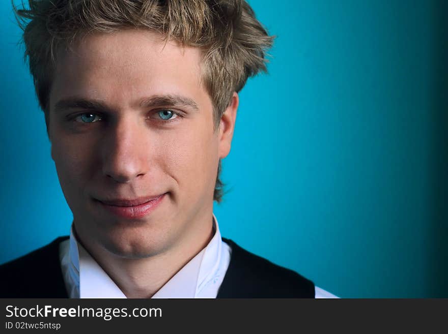 The guy with blue eyes against a turquoise wall