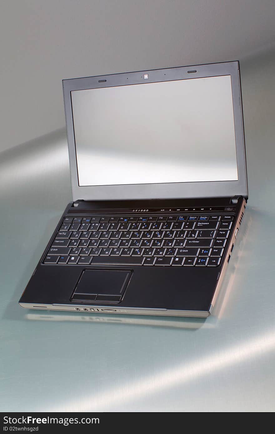 Laptop on a gray table with reflection