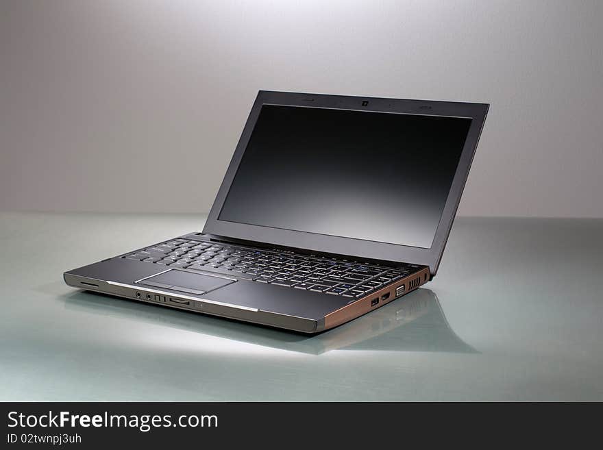 Laptop on a gray table with reflection