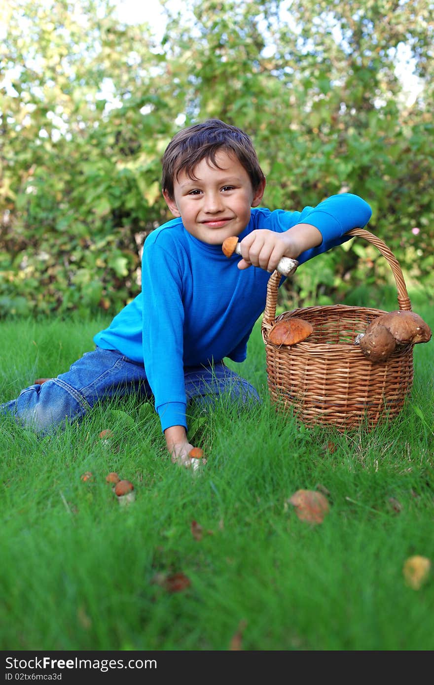 Little boy posing outdoors with mushrooms. Little boy posing outdoors with mushrooms