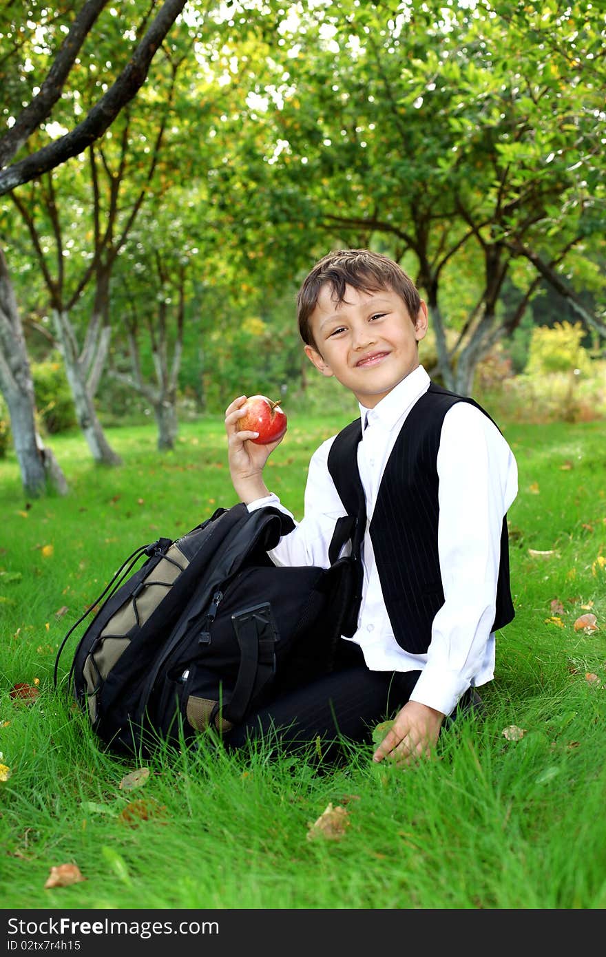 Schoolboy with backpack and apple outdoors. Schoolboy with backpack and apple outdoors