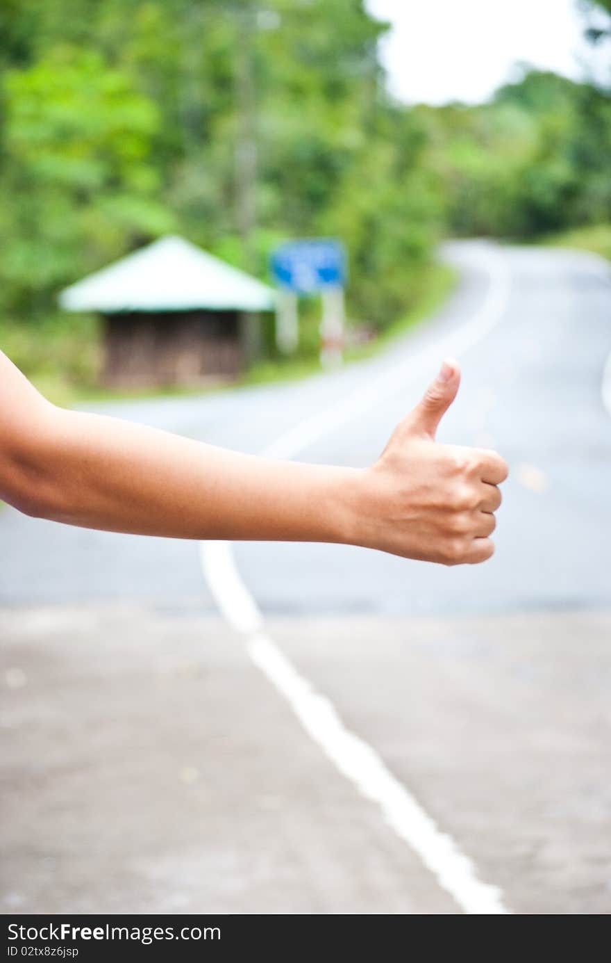 ้Hand thumb outstretched hitchhiking on road. ้Hand thumb outstretched hitchhiking on road