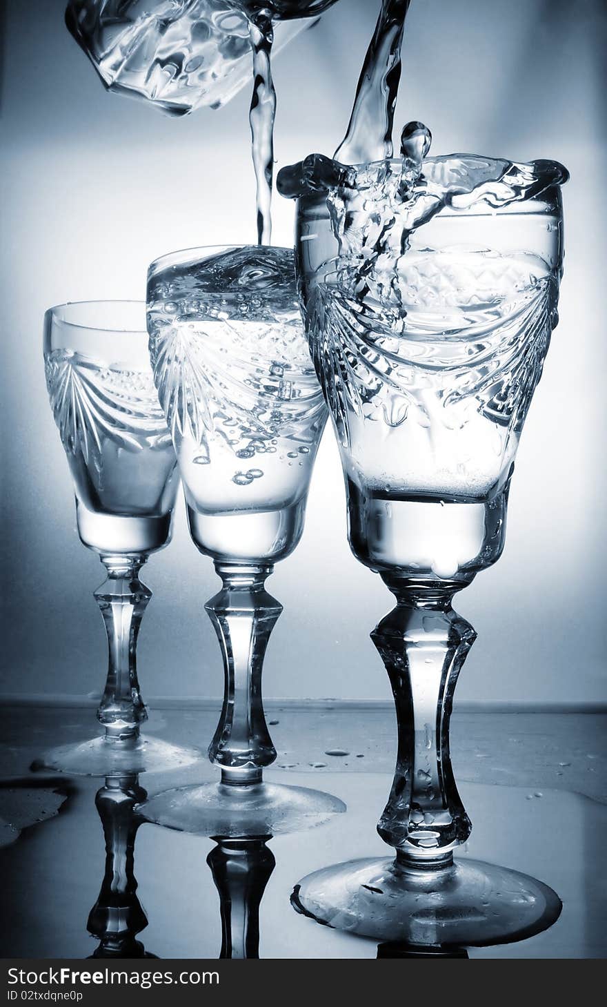 Flowing water in a glass in dark blue color