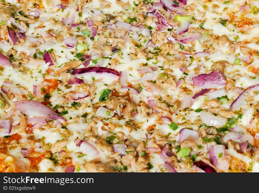 A pizza surfaced with tunny and red onion