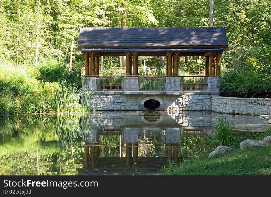 Peaceful setting with park pavilion and reflection in pond. Peaceful setting with park pavilion and reflection in pond.