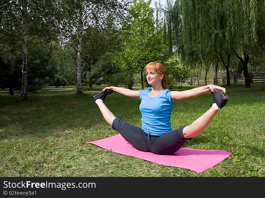 Woman engages in yoga, sits on buttocks in splits. Woman engages in yoga, sits on buttocks in splits