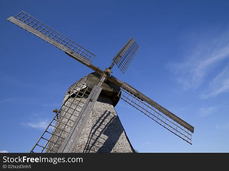 Old wooden windmill against the blue sky