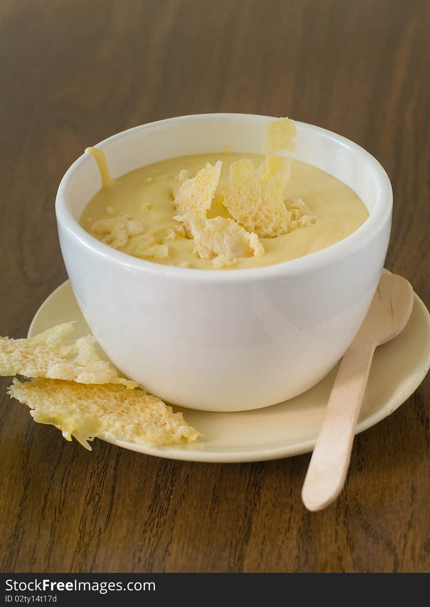 Bowl of cheese soup on plate with cheese chips