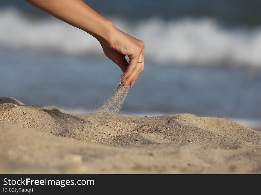 hand pours sand