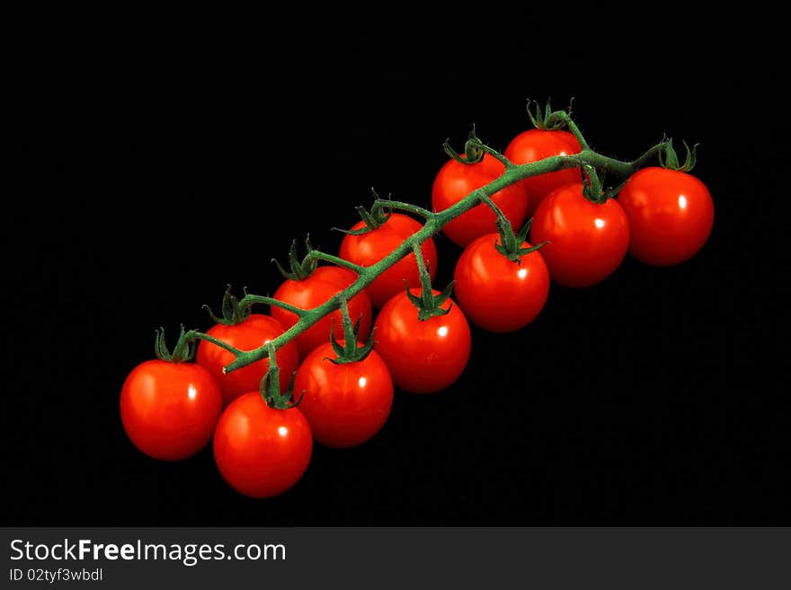 Bunch of red tomatoes on a black background