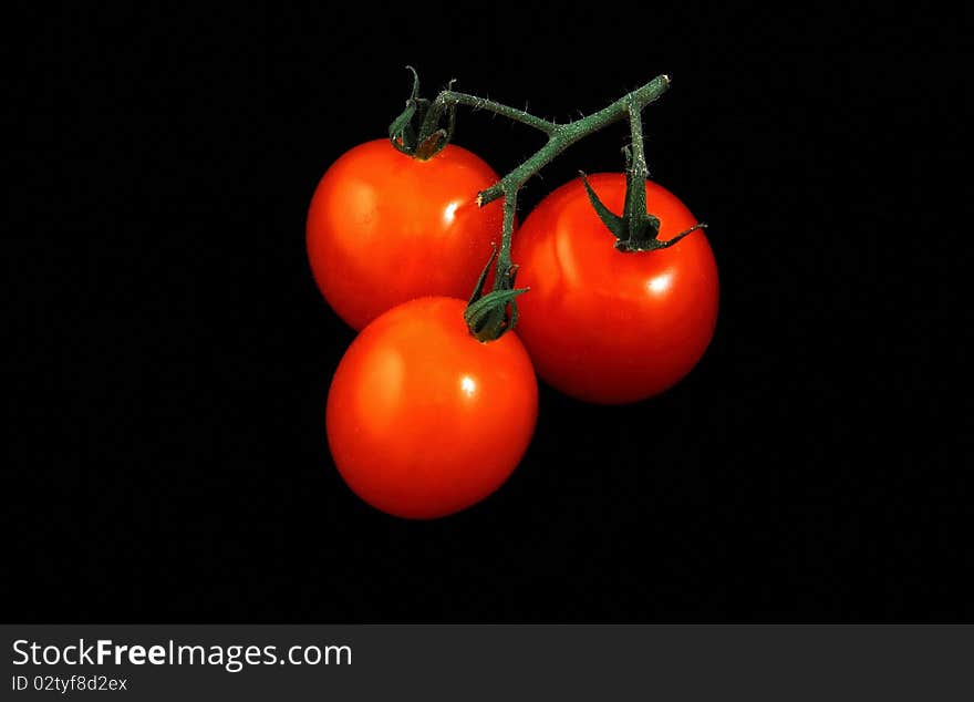 Bunch of red tomatoes on a black background is