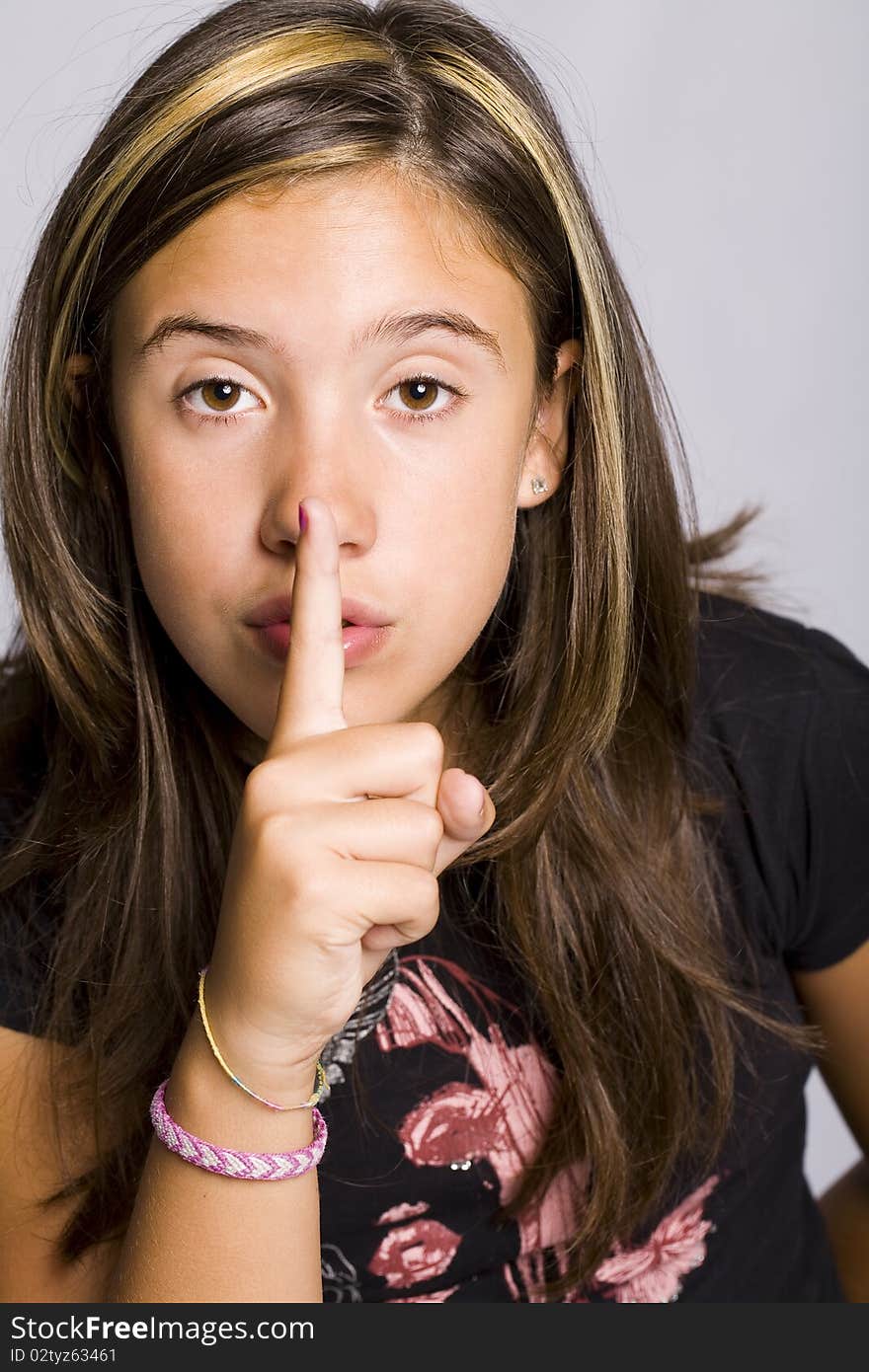 Young girl making a silence sign with her finger. Young girl making a silence sign with her finger