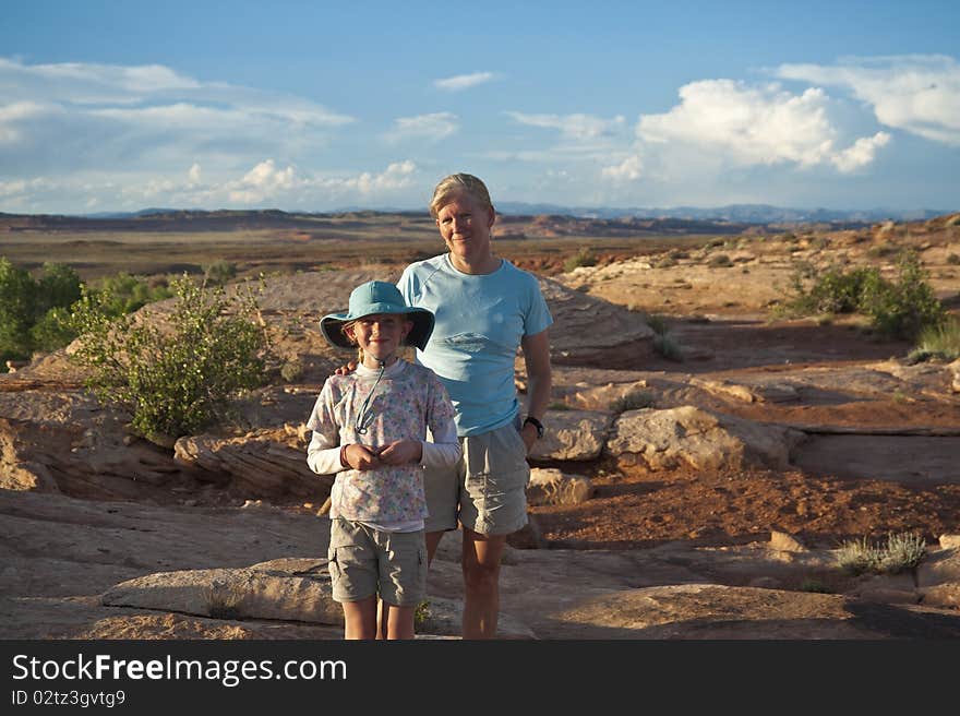 Mother and daughter pausing on a hike in the desert. Mother and daughter pausing on a hike in the desert