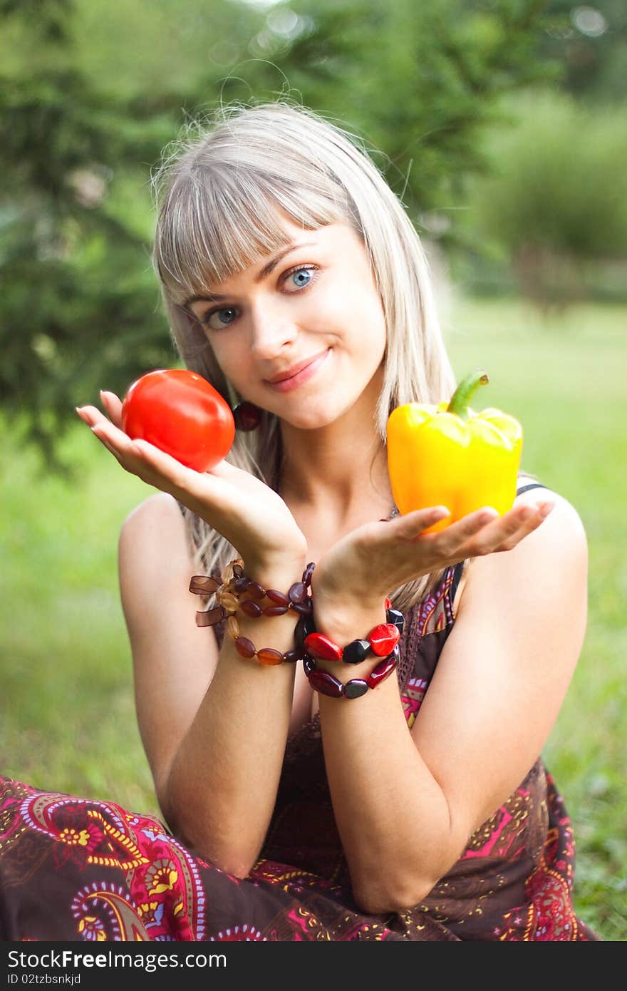 Girl holding a pepper and tomato