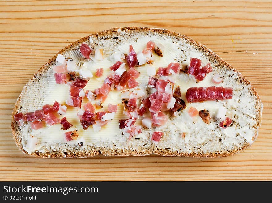 A bread with butter and cracklings on a wooden table. A bread with butter and cracklings on a wooden table