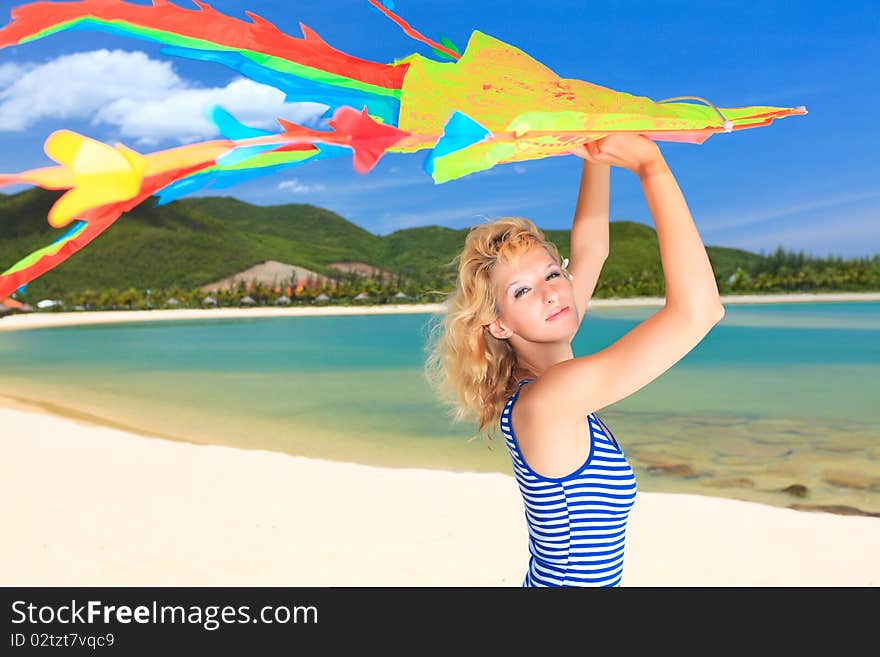 Young woman with kite on the beach