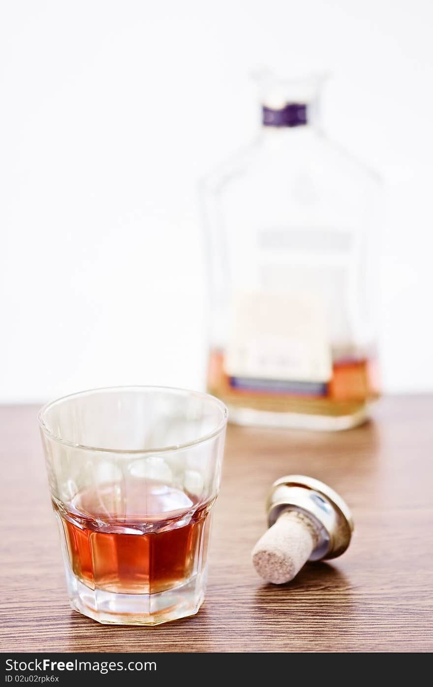 Whiskey glass and bottle on wooden counter