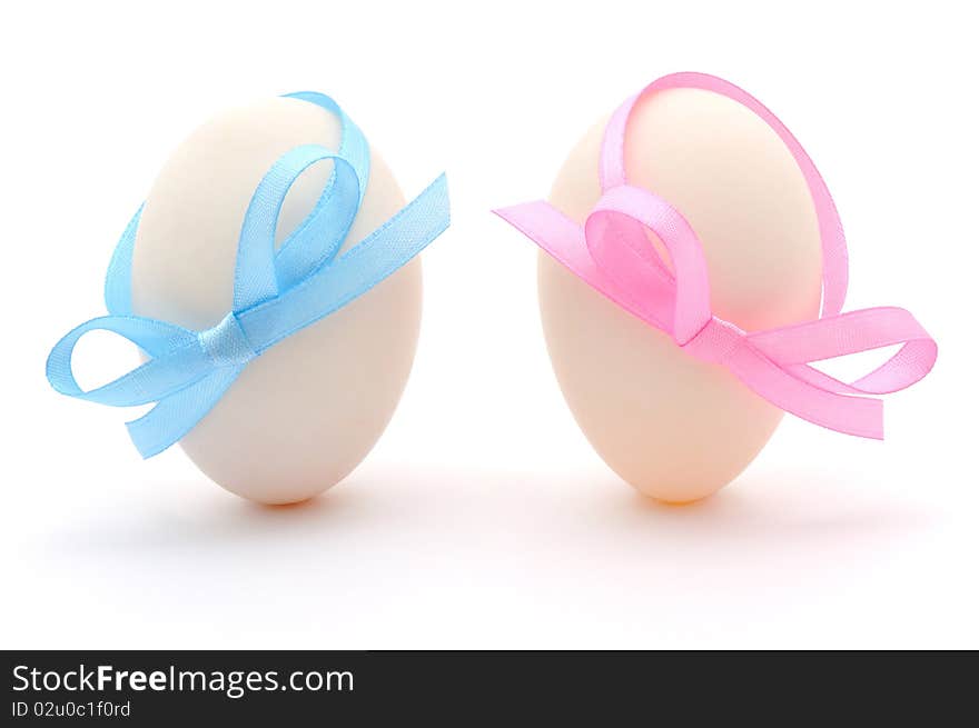 White eggs with ribbons over white background