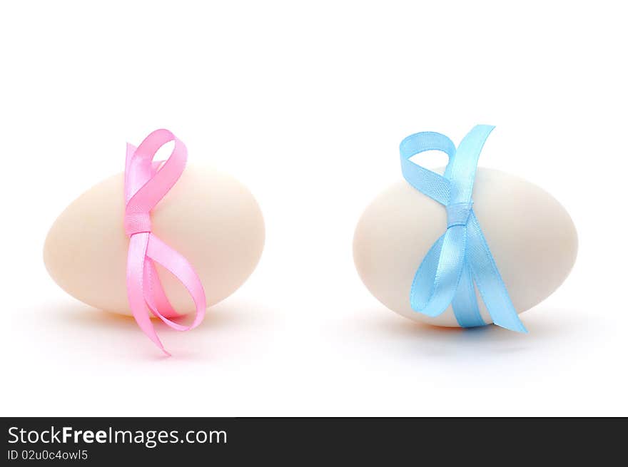 White eggs with ribbons over white background