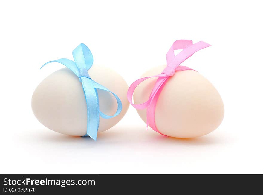 White eggs with ribbons over white background