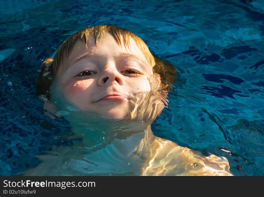 Child enjoys swimming in the pool