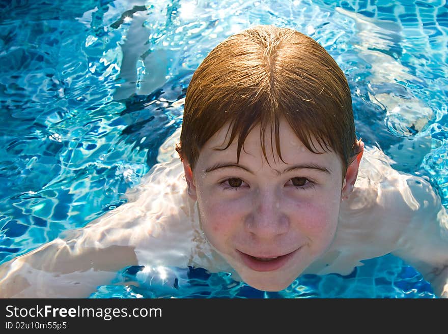 Boy with red hair is swimming in the pool and enyo. Boy with red hair is swimming in the pool and enyo