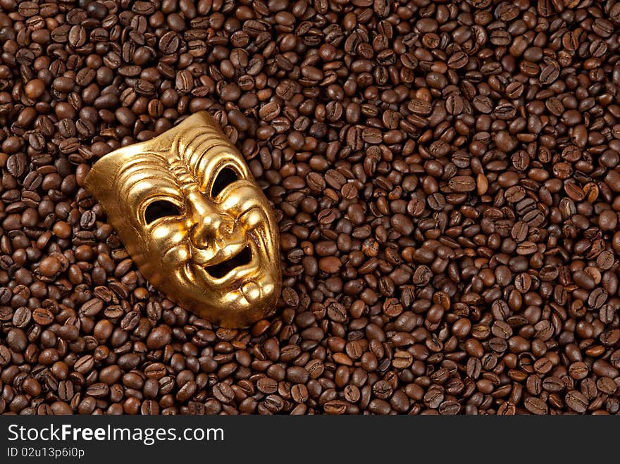 Gold mask on coffee beans background.