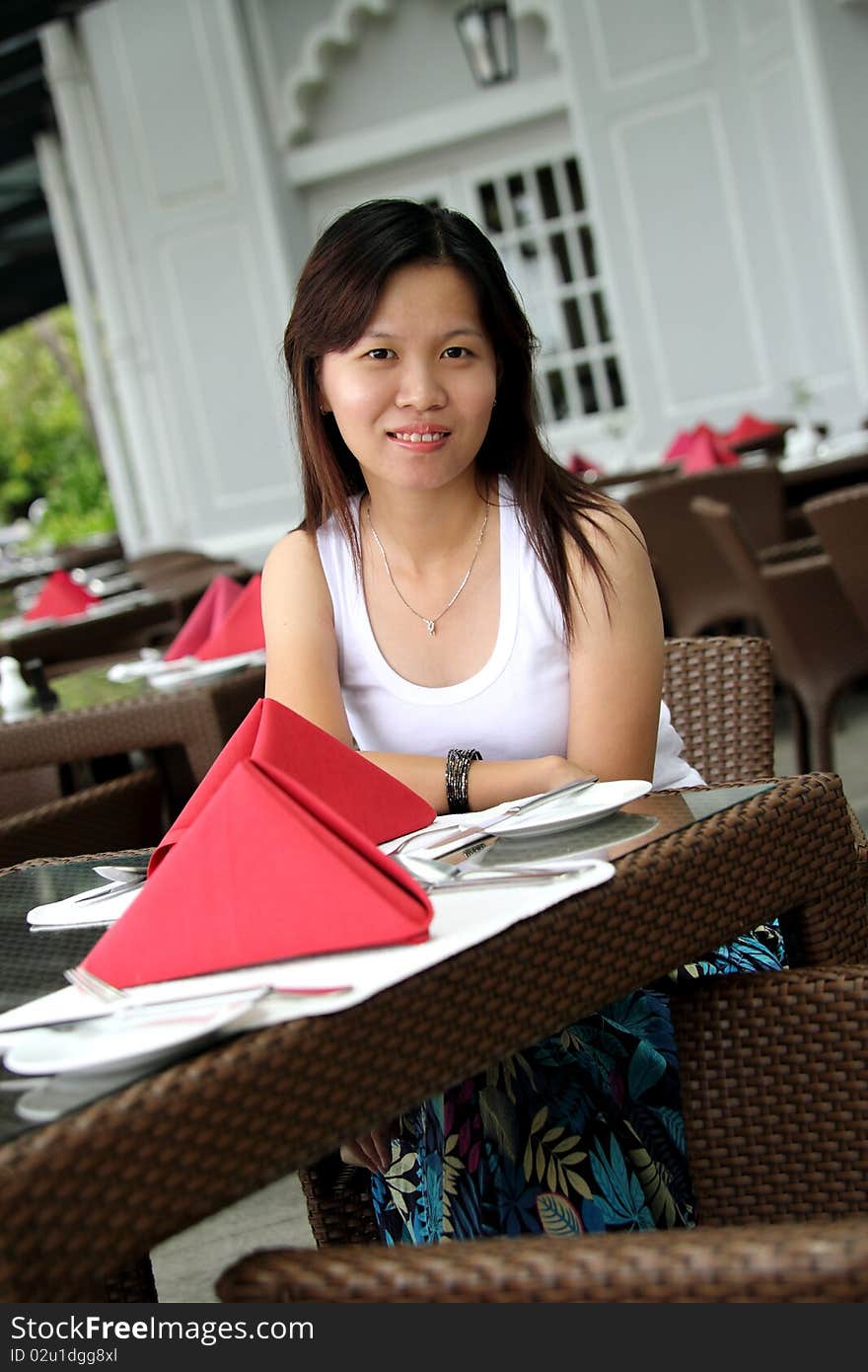 Image of a young Asian lady smiling at restaurant. Image of a young Asian lady smiling at restaurant