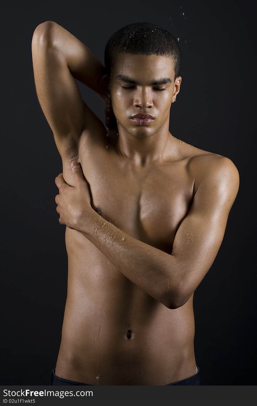 Drops of the water on naked body of a young man on black background. Drops of the water on naked body of a young man on black background.